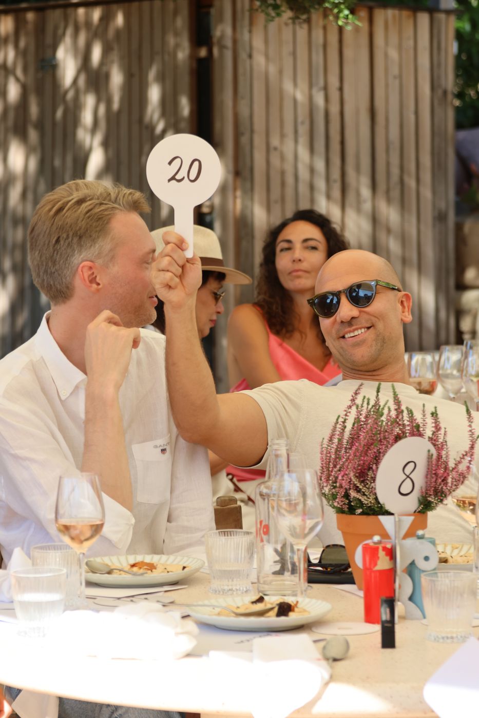 Guests at a lunch table cheer as paddle 20 goes up.